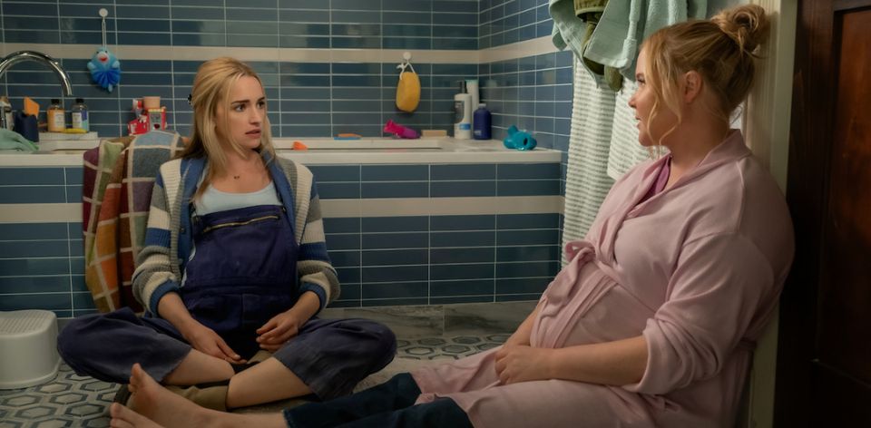 Kinda Pregnant (2025) - Brianne Howey and Amy Schumer sit on a bathroom floor talking