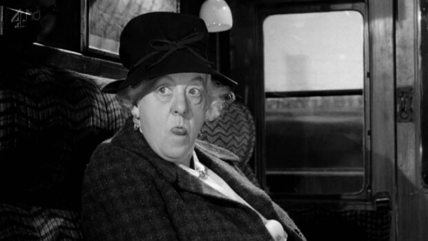 Margaret Rutherford as Miss Marple pulling a face while riding a train in Murder, She Said (1961).